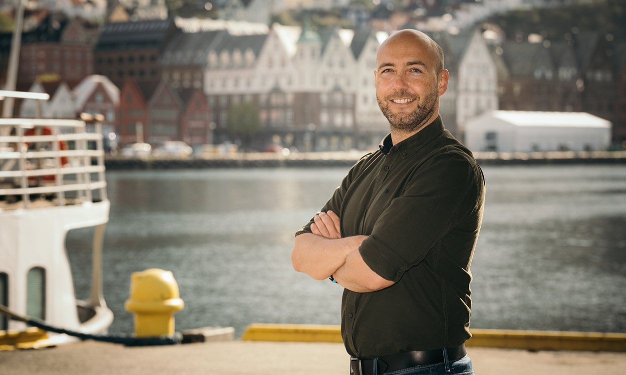 Stian Revheim står nede ved Vågen i Bergen med Bryggen i bakgrunnen. 